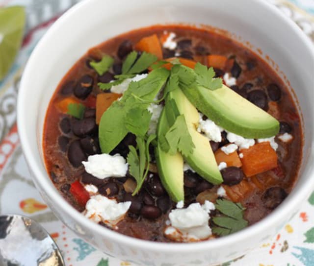 Bowl of black bean soup garnished with parsley