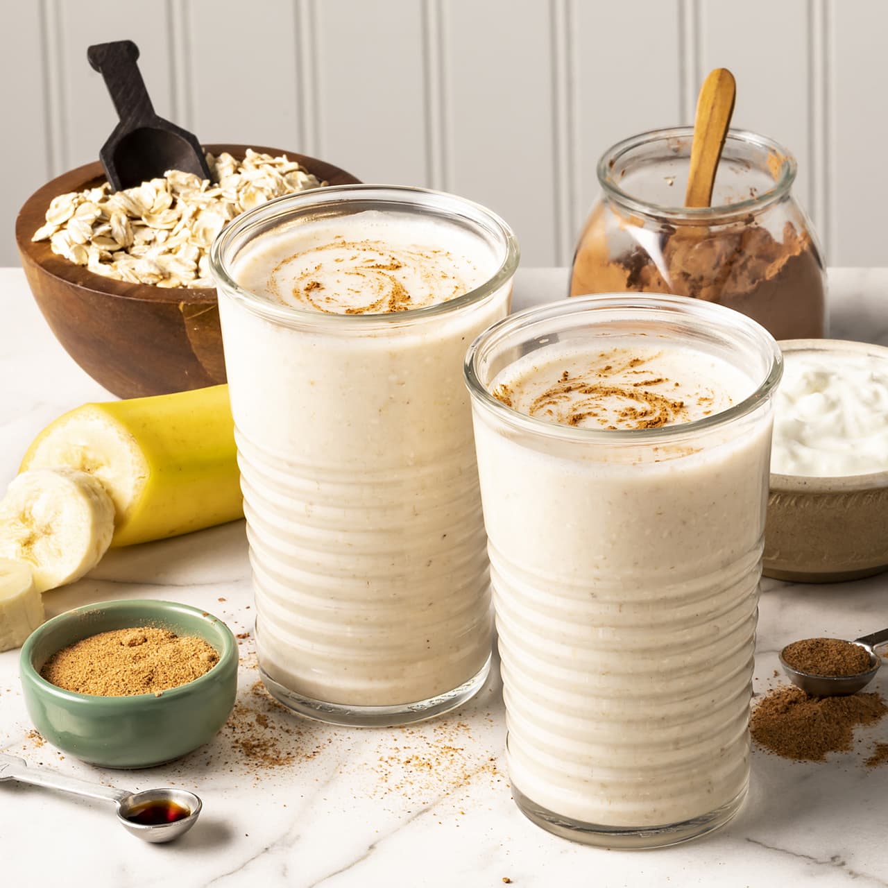 Two dairy-free banana bread smoothies topped with cinnamon
