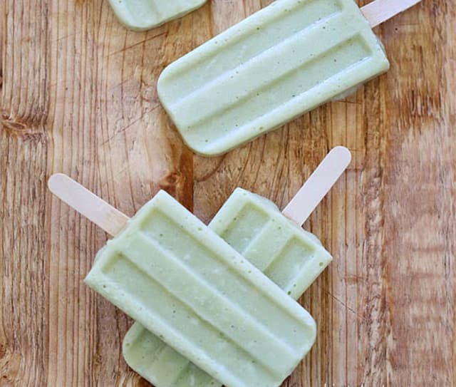 Three avocado coconut popsicles on a tabletop