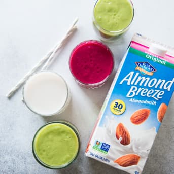 Four smoothies next to Almond Breeze Unsweetened Original Almondmilk