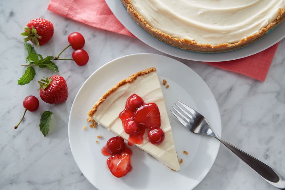 Slice of no bake cheesecake topped with fresh strawberries
