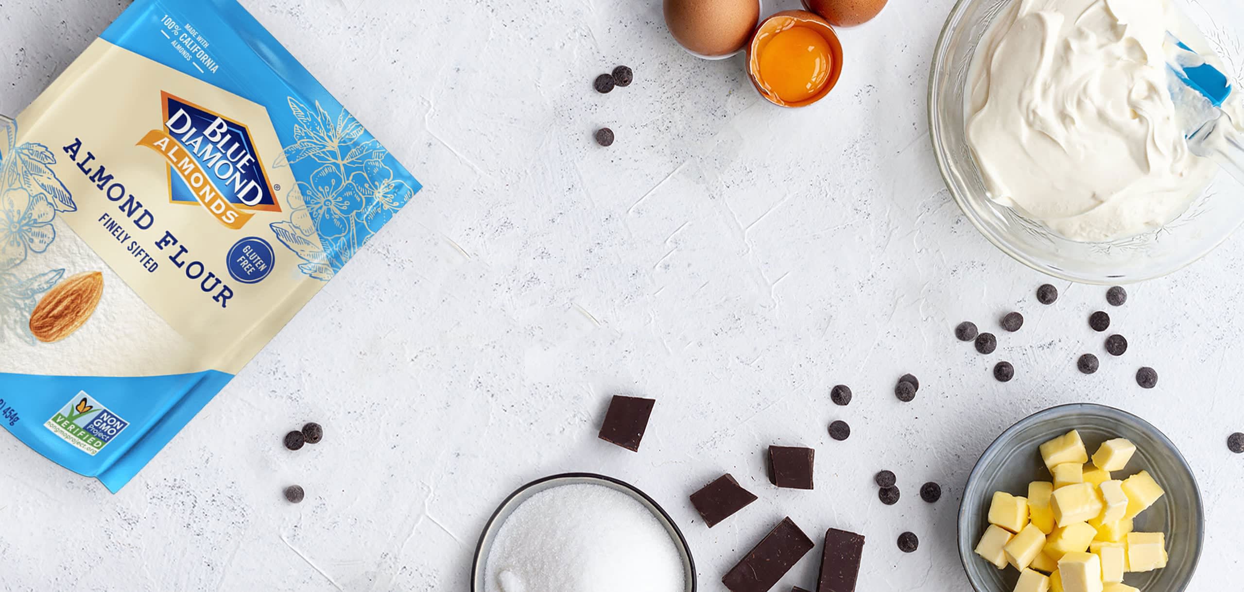 One pound bag of Blue Diamond finely sifted almond flour on a tabletop with cracked egg and other condiments